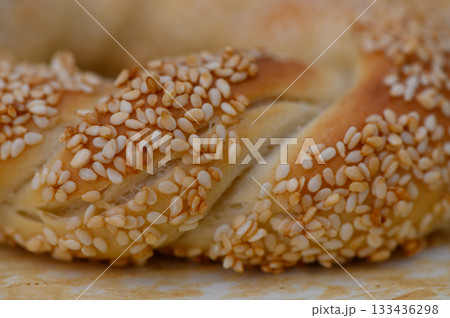 Golden braided bread adorned with sesame seeds showcases culinary artistry in a sunlit kitchen Golden braided bread adorned with sesame seeds showcases culinary artistry in a sunlit kitchen 133436298