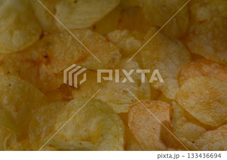 Crunchy potato chips create a tempting snack experience during a cozy movie night at home 133436694