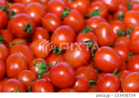 Fresh ripe tomatoes piled high at a vibrant farmer's market during the sunny afternoon in late summer 133436754