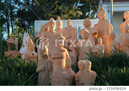 Stunning collection of terracotta sculptures displayed in serene outdoor setting during golden hour 133436824