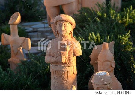 Ethereal terracotta figurines grace a sunlit garden in the heart of cultural heritage, showcasing artistry from ancient civilizations 133436849