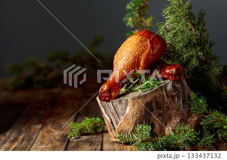 Smoked chicken drumsticks and juniper branches on a wooden table. Smoked chicken drumsticks and juniper branches on a wooden table. 133437132