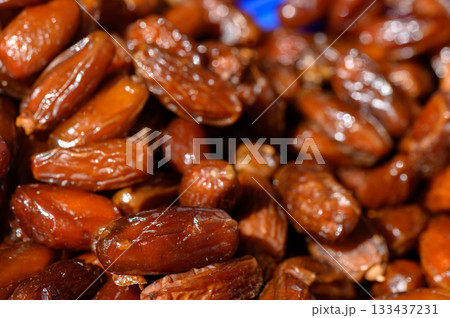 Rich and glossy Medjool dates piled together, showcasing their natural sweetness and vibrant color during a market display 133437231