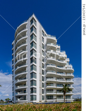 Modern architectural marvel rises against a brilliant blue sky in a coastal paradise 133437541