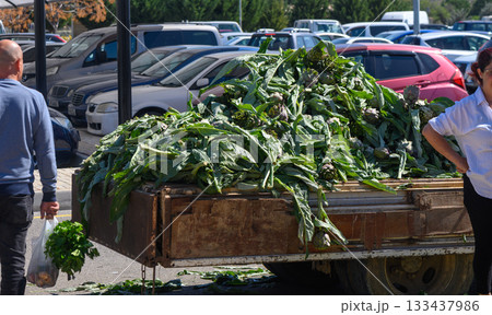Bountiful harvest of fresh greens at a bustling market during midday 133437986