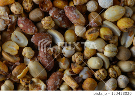 Colorful assortment of roasted nuts displayed in a rustic wooden bowl at an outdoor gathering during a sunny afternoon 133438020