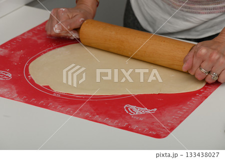 Rolling dough with care on a vibrant work surface during a joyful baking session at home 133438027