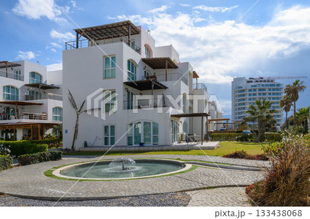 Luxury seaside villa surrounded by lush greenery with a tranquil fountain, ideal for relaxation and rejuvenation near the coast 133438068