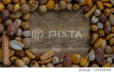 Colorful assortment of snacks encircles a wooden surface inviting a moment of sharing and enjoyment 133438166