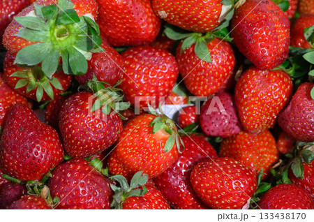 Vibrant red strawberries glistening in the sunlight at a bustling farmers market during summer harvest season Vibrant red strawberries glistening in the sunlight at a bustling farmers market during summer harvest season 133438170