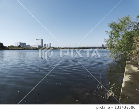 快晴の多摩川二丁目河川敷から望む多摩川の水面と川崎側の街並み 133438380