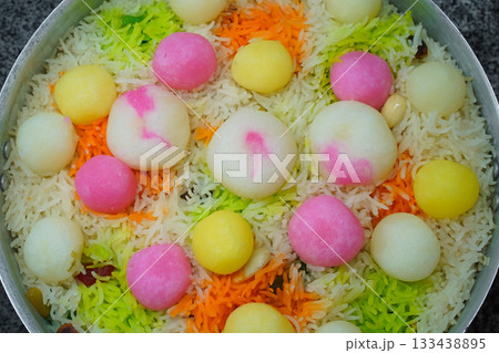 Mutanjan, sweet colored rice with rasgulla and cham cham colorful balls, almonds and marmalade, prepared for serving as niyaz. Close-up and top view of a traditional islamic festive sweet dish. Mutanjan, sweet colored rice with rasgulla and cham cham colorful balls, almonds and marmalade, prepared for serving as niyaz. Close-up and top view of a traditional islamic festive sweet dish. 133438895