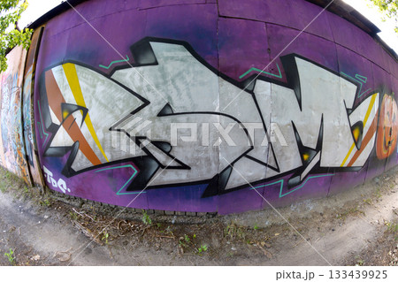 Fisheye shot of street art graffiti drawing on wall. Spray art artwork with different colors and outlines. Illegal vandalism concept 133439925