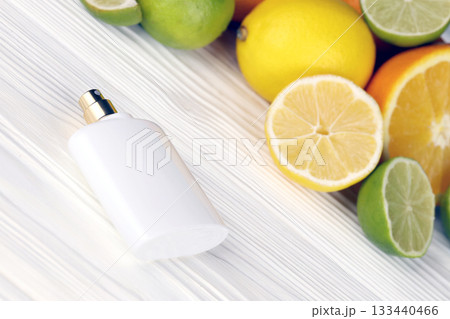 Perfume with citrus extracts. Selective focus. Spa day, concept of freshness perfume bottle with lemon lime and orange slices 133440466