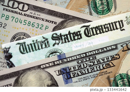 United States Treasury refund check or stimulus bill with many hundred dollars banknotes close up 133441642