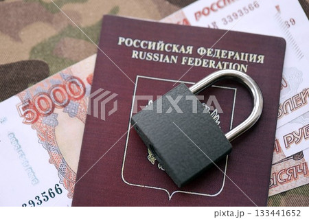 Russian rubles money bills and passport under ban of heavy lockpad close up. Concept of sanctions and restrictions to russian citizens 133441652