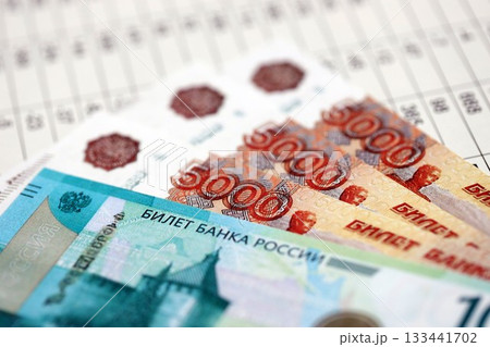 Russian rubles or roubles money bills banknotes on document with business calculations table close up. Business, investment and taxation in Russian Federation Russian rubles or roubles money bills banknotes on document with business calculations table close up. Business, investment and taxation in Russian Federation 133441702