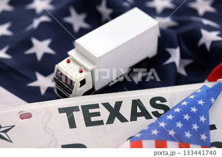 Toy truck and USA state of Texas license plate on US flag. Concept of driving in Texas. Reaching a driving permit Toy truck and USA state of Texas license plate on US flag. Concept of driving in Texas. Reaching a driving permit 133441740