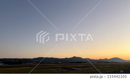 夕暮れに染まる空港と山並み 133442105