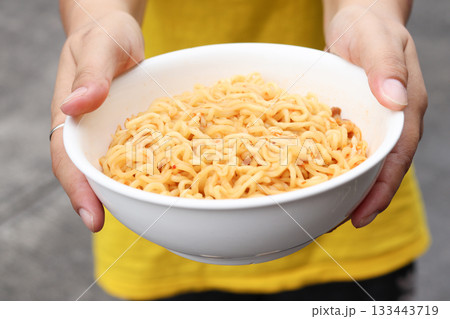 Spicy instant noodles bowl and hand Spicy instant noodles bowl and hand 133443719