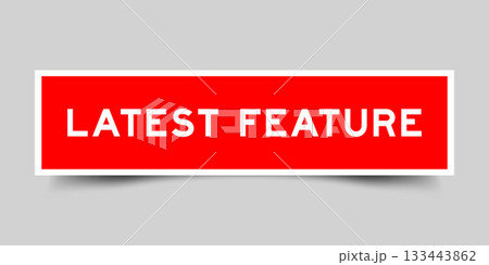 Red color square shape sticker label with word latest feature on gray background Red color square shape sticker label with word latest feature on gray background 133443862