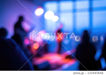 Blurred live band performing on stage with colorful neon lights, defocused audience clapping, vibrant atmosphere, indoor concert, energetic mood, music event, night scene 133445648