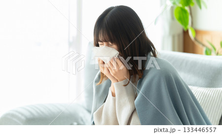 風邪を引いてくしゃみをする女性 133446557
