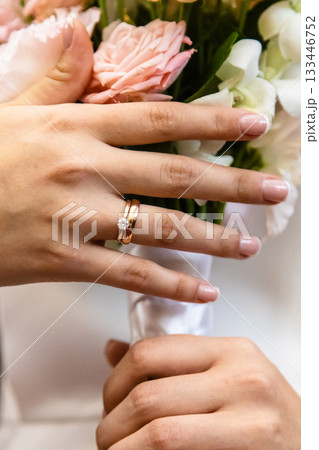 bride hands with wedding ring and wedding bouquet 133446752