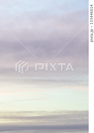 banded blue, light gray, yellow cloudy sky in dusk 133446814