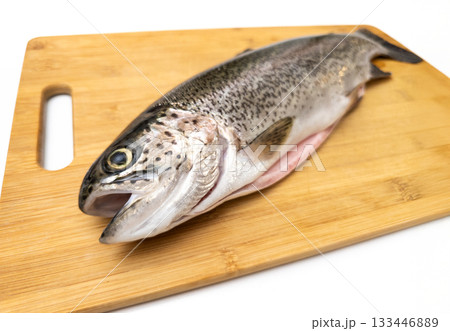 A fish is on a wooden cutting board 133446889