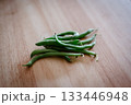 木目のテーブルに置かれたさやいんげん 133446948