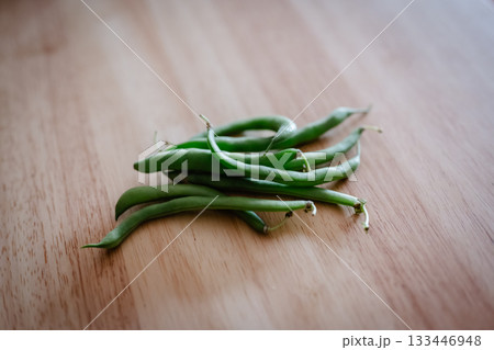 木目のテーブルに置かれたさやいんげん 133446948