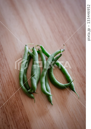 木目のテーブルに置かれたさやいんげん 133446952
