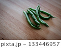 木目のテーブルに置かれたさやいんげん 133446957