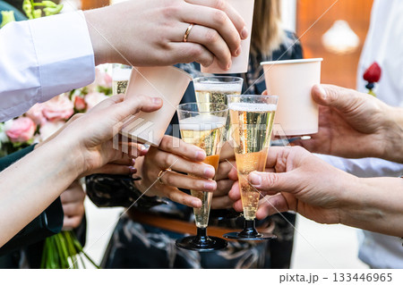 guests clink with glass goblets and paper cups 133446965
