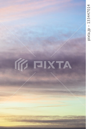 striped blue, dark gray, yellow cloudy sky in dusk 133447014