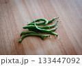 木目のテーブルに置かれたさやいんげん 133447092