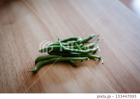 木目のテーブルに置かれたさやいんげん 133447093