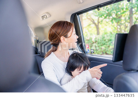 子どもと一緒にタクシーに乗って外を眺めるお母さん 133447635