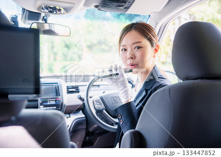 外国人への接客のために翻訳アプリを使う女性タクシードライバー 外国人への接客のために翻訳アプリを使う女性タクシードライバー 133447852