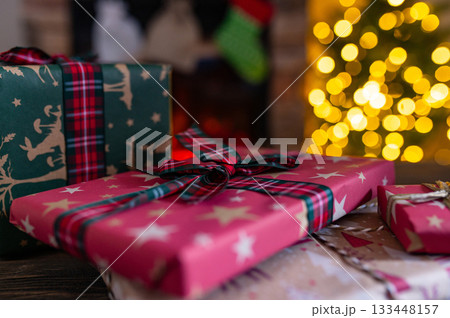 Cozy Christmas Interior with Fireplace, Gift Boxes, and Decorated Tree with Warm Lights 133448157