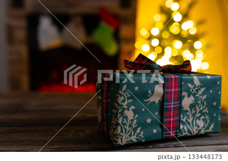 Cozy Christmas Interior with Fireplace, Gift Boxes, and Decorated Tree with Warm Lights Cozy Christmas Interior with Fireplace, Gift Boxes, and Decorated Tree with Warm Lights 133448173