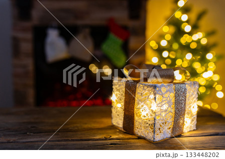 Cozy Christmas Interior with Fireplace, Gift Boxes, and Decorated Tree with Warm Lights Cozy Christmas Interior with Fireplace, Gift Boxes, and Decorated Tree with Warm Lights 133448202