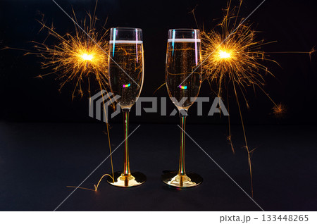 Happy New Year 2026, New Year's Eve holiday greeting card celebration. Sparklers firework, champagne glasses on black background 133448265