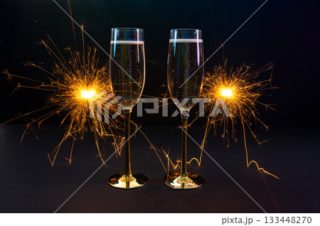 Happy New Year 2026, New Year's Eve holiday greeting card celebration. Sparklers firework, champagne glasses on black background 133448270