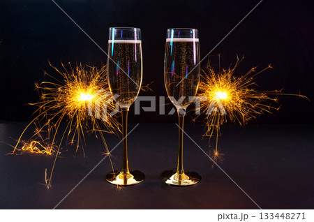 Happy New Year 2026, New Year's Eve holiday greeting card celebration. Sparklers firework, champagne glasses on black background 133448271