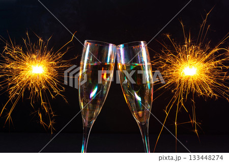 Happy New Year 2026, New Year's Eve holiday greeting card celebration. Sparklers firework, champagne glasses on black background 133448274