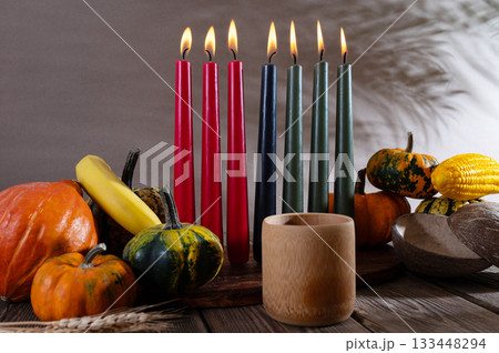 Kwanzaa, african holiday Kwanzaa with decoration of seven candles in red, black and green colors, vegetable harvest, corn. Greeting card banner. Happy Kwanzaa Kwanzaa, african holiday Kwanzaa with decoration of seven candles in red, black and green colors, vegetable harvest, corn. Greeting card banner. Happy Kwanzaa 133448294