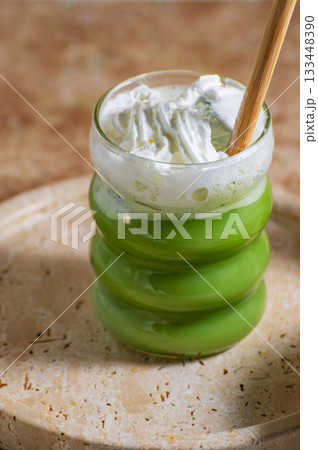 Matcha latte glass, matcha bowl, a bamboo whisk Chasen on travertine tray 133448390