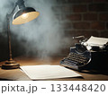 Vintage typewriter on a wooden desk under a glowing lamp 133448420